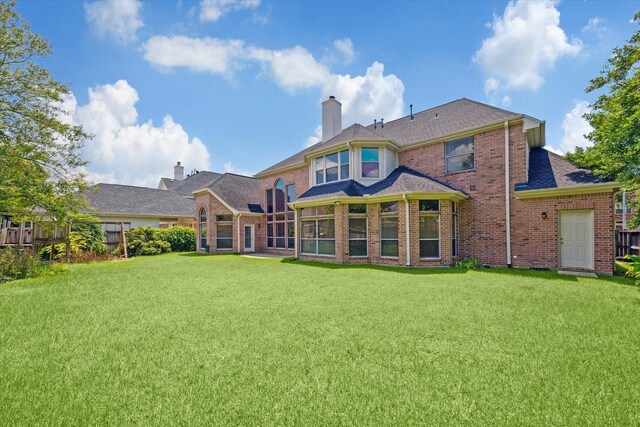 rear view of house featuring a yard