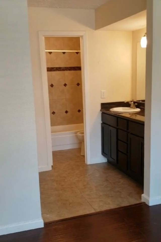 full bathroom featuring toilet, hardwood / wood-style floors, vanity, and tiled shower / bath