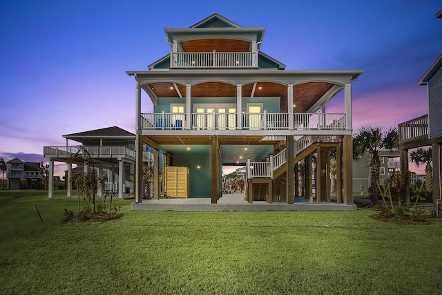 back house at dusk with a yard and a patio