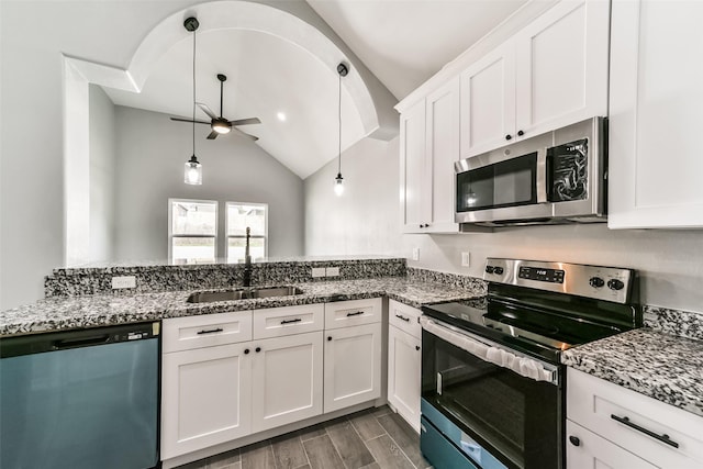 kitchen with stainless steel appliances, dark stone counters, white cabinets, and ceiling fan