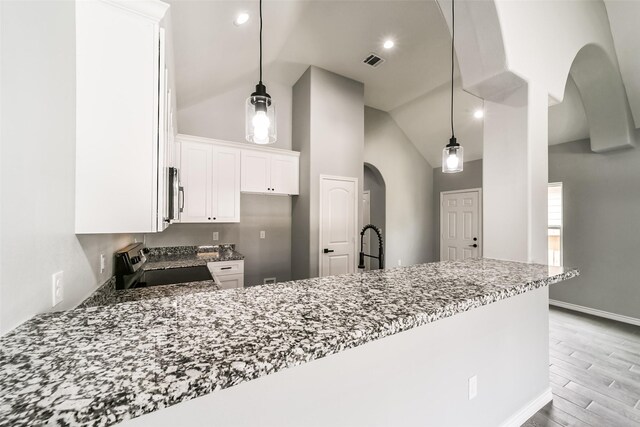 kitchen featuring white cabinetry, light stone counters, kitchen peninsula, and stainless steel range with electric cooktop