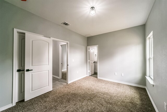 unfurnished bedroom featuring carpet and multiple windows