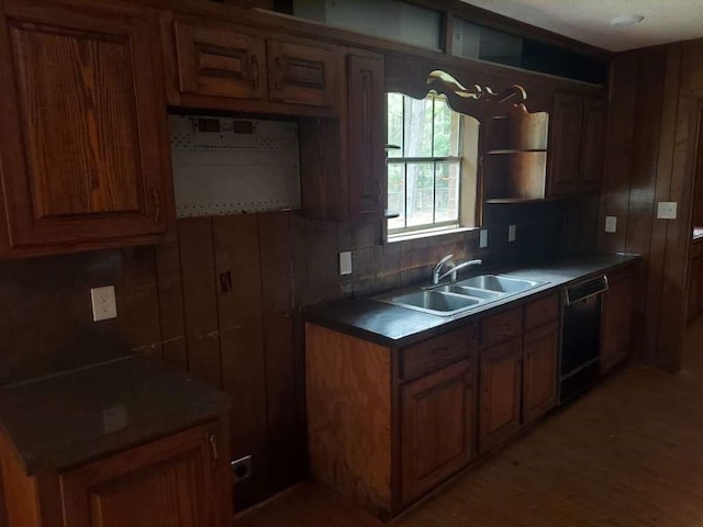 kitchen featuring backsplash, black dishwasher, sink, and hardwood / wood-style floors