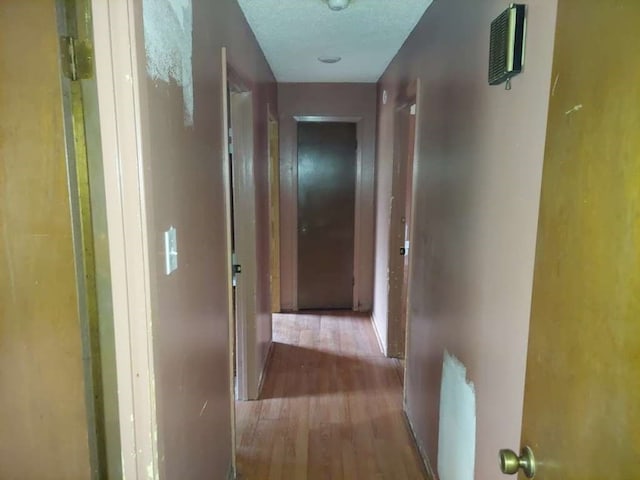 hallway featuring a textured ceiling and wood-type flooring