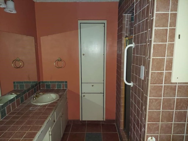 bathroom with a shower with shower door, vanity, and tile patterned flooring