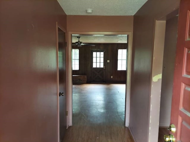 hall featuring wood-type flooring and a textured ceiling