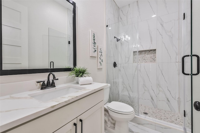 bathroom featuring vanity, a shower with shower door, and toilet