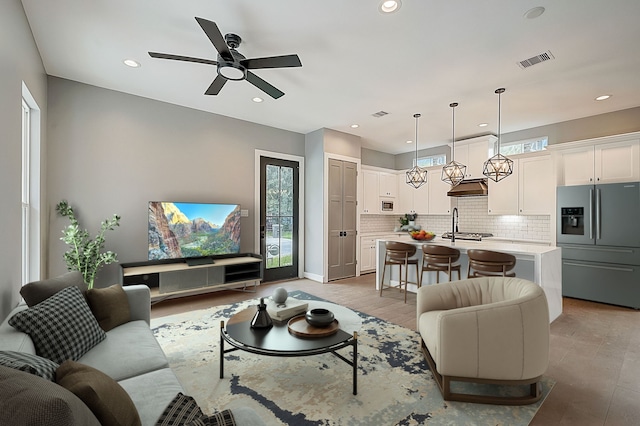 living room with ceiling fan and light hardwood / wood-style flooring