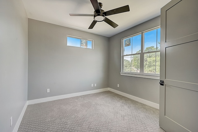 carpeted empty room featuring ceiling fan and a healthy amount of sunlight