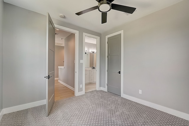 unfurnished bedroom with light carpet, ensuite bath, and ceiling fan