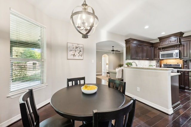 dining room featuring dark hardwood / wood-style floors, ceiling fan with notable chandelier, and ornamental molding