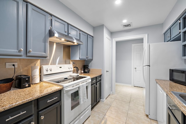 kitchen featuring white appliances, light stone countertops, light tile patterned floors, and backsplash