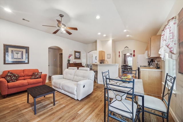 living room with light hardwood / wood-style flooring, vaulted ceiling, and ceiling fan