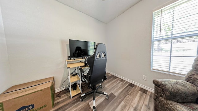 home office with wood-type flooring, plenty of natural light, and vaulted ceiling