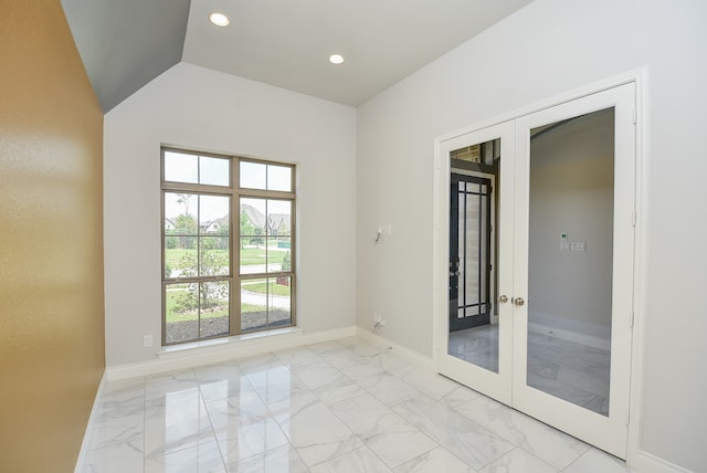 empty room with french doors, light tile patterned floors, and vaulted ceiling