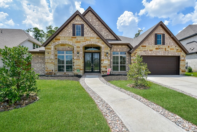 view of front of property with a garage, french doors, and a front lawn