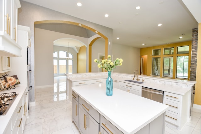 kitchen featuring light tile patterned flooring, appliances with stainless steel finishes, sink, a kitchen island, and kitchen peninsula