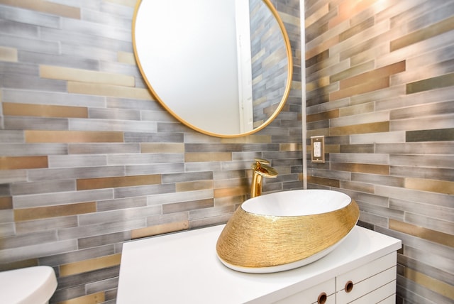 bathroom featuring tile walls, vanity, and toilet