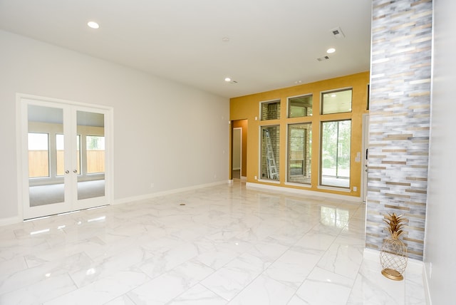 tiled spare room featuring french doors