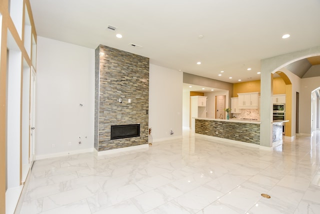 unfurnished living room featuring a fireplace and light tile patterned floors