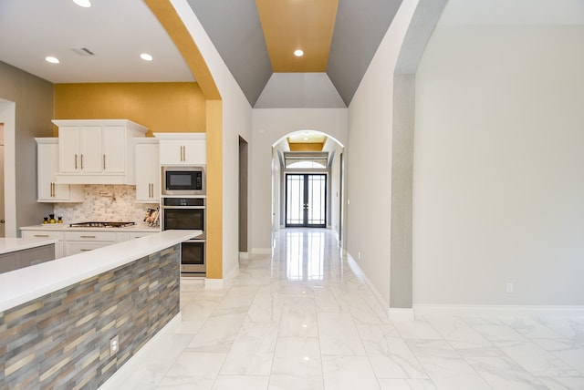 kitchen featuring tasteful backsplash, black microwave, gas cooktop, and light tile patterned floors