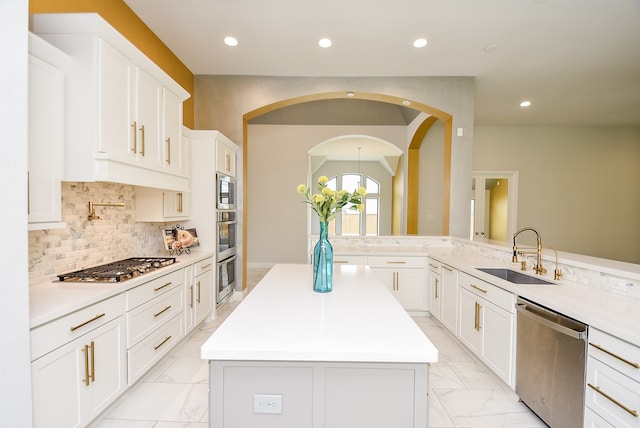 kitchen featuring appliances with stainless steel finishes, sink, light tile patterned flooring, and a kitchen island