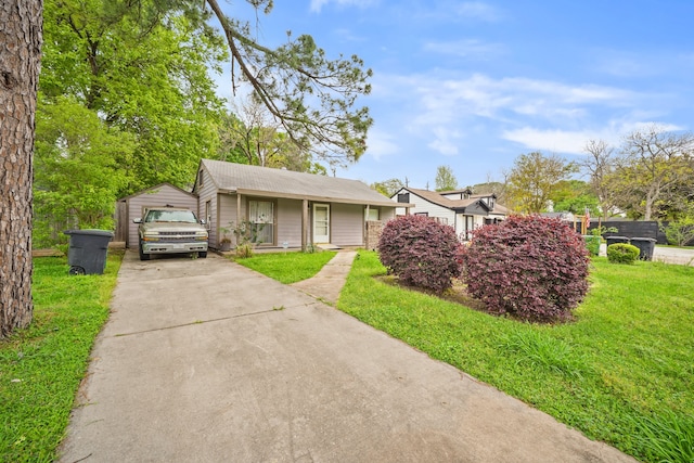 view of front of property with a garage, a front lawn, and an outdoor structure