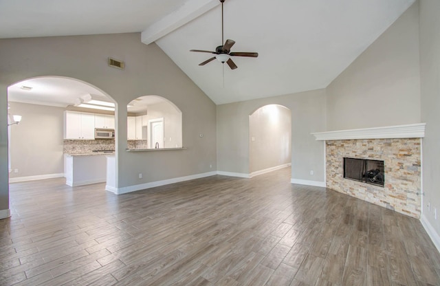 unfurnished living room with ceiling fan, a fireplace, high vaulted ceiling, and wood-type flooring