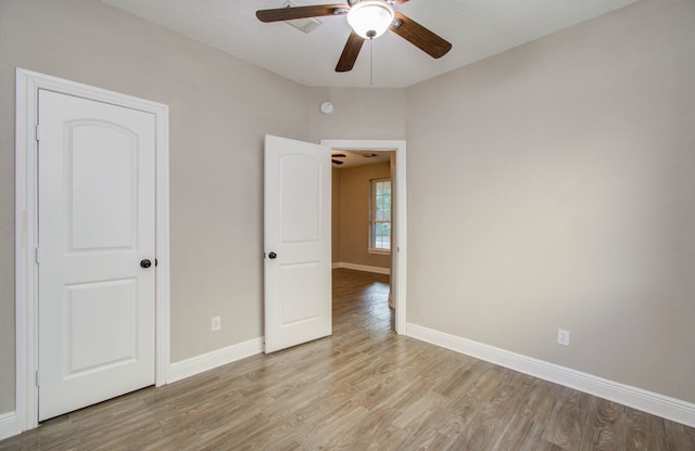 unfurnished bedroom with ceiling fan and light wood-type flooring