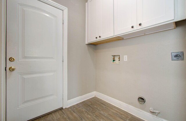 laundry area featuring cabinets, light hardwood / wood-style floors, electric dryer hookup, hookup for a gas dryer, and washer hookup