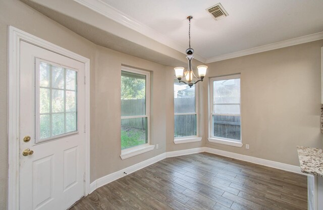 unfurnished dining area with ornamental molding, dark hardwood / wood-style flooring, a chandelier, and a wealth of natural light