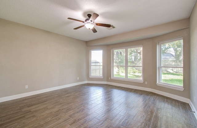 empty room with ceiling fan, wood-type flooring, and a wealth of natural light