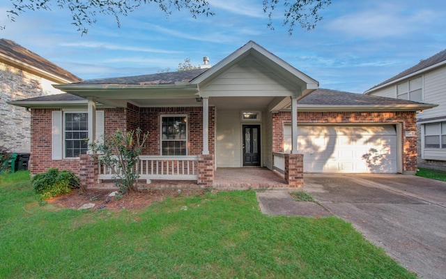 view of front facade with a porch, a garage, and a front lawn