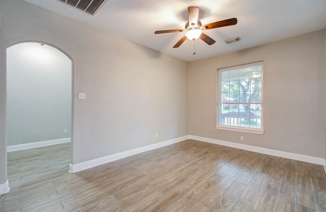 empty room featuring a textured ceiling, ceiling fan, and light hardwood / wood-style floors