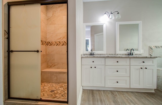 bathroom with vanity, hardwood / wood-style floors, and tiled shower