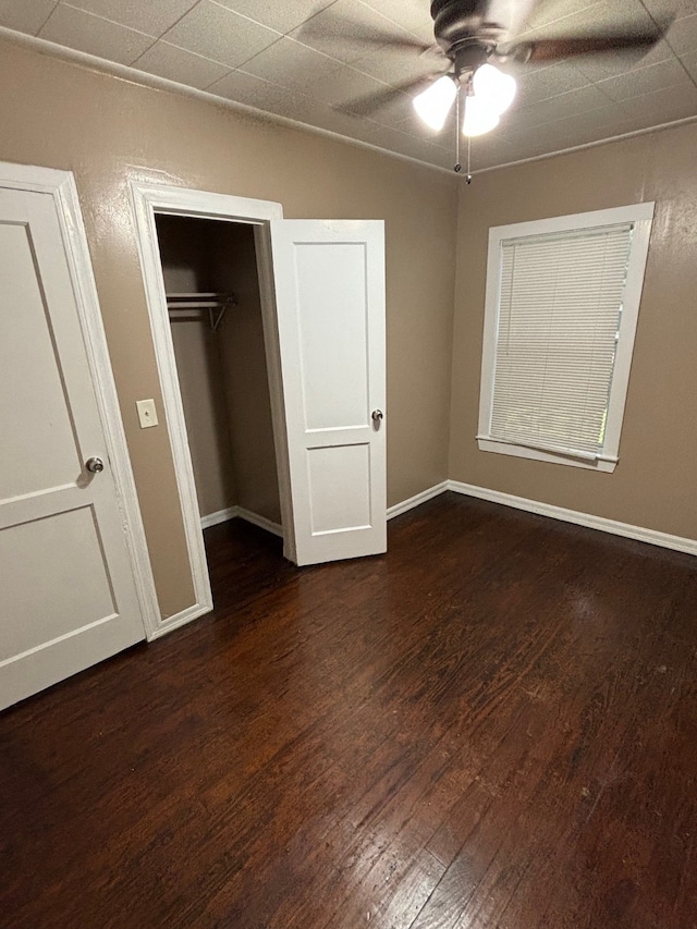 unfurnished bedroom featuring ceiling fan, a closet, and dark hardwood / wood-style floors