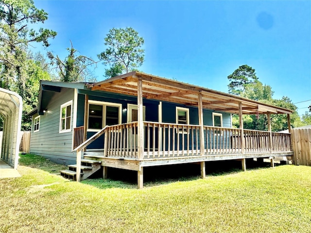 back of house featuring a wooden deck and a lawn