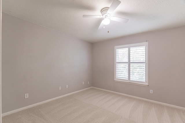 carpeted empty room with ceiling fan and a textured ceiling