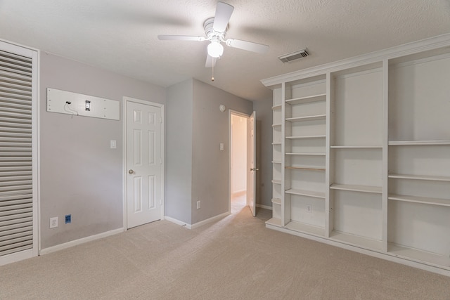 unfurnished bedroom with ceiling fan, a textured ceiling, and light colored carpet