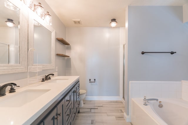 full bathroom featuring double vanity, toilet, plus walk in shower, and hardwood / wood-style flooring