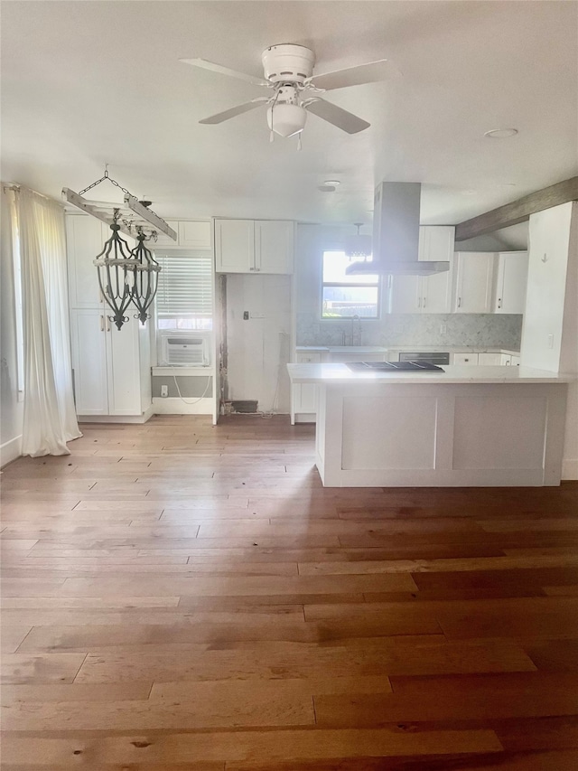 kitchen featuring white cabinets, light hardwood / wood-style flooring, and wall chimney exhaust hood