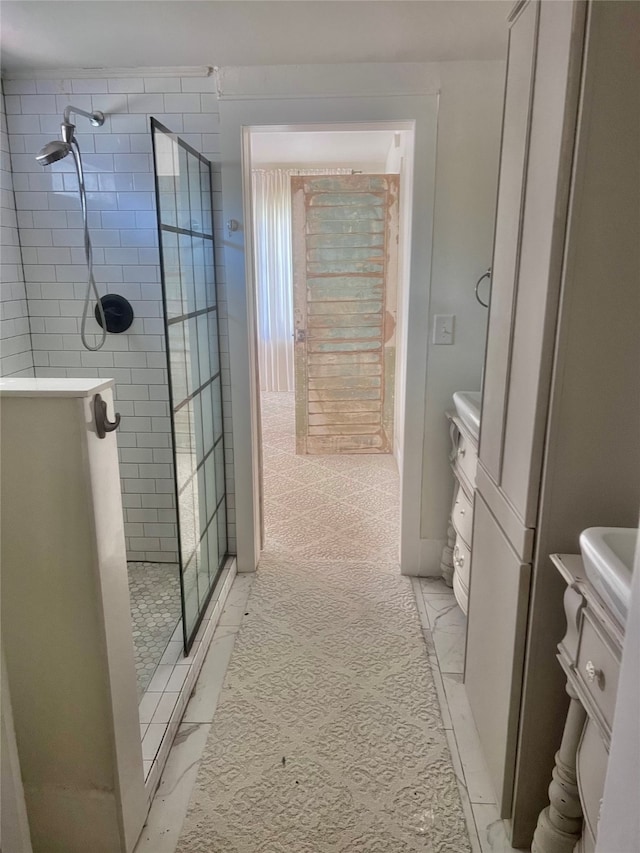 bathroom featuring a shower with shower door, vanity, and tile patterned flooring