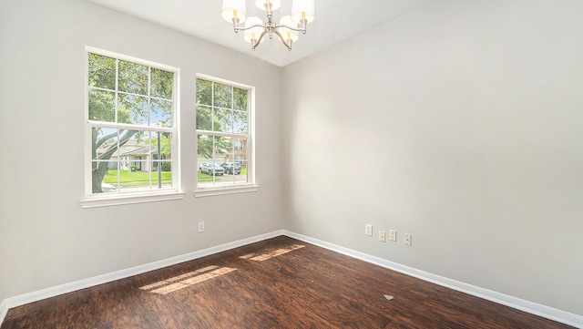 spare room featuring a notable chandelier and hardwood / wood-style floors