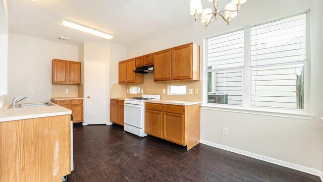 kitchen featuring dark hardwood / wood-style flooring, an inviting chandelier, gas range gas stove, plenty of natural light, and sink