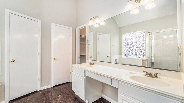 bathroom featuring a shower with shower door, double sink vanity, vaulted ceiling, and hardwood / wood-style flooring