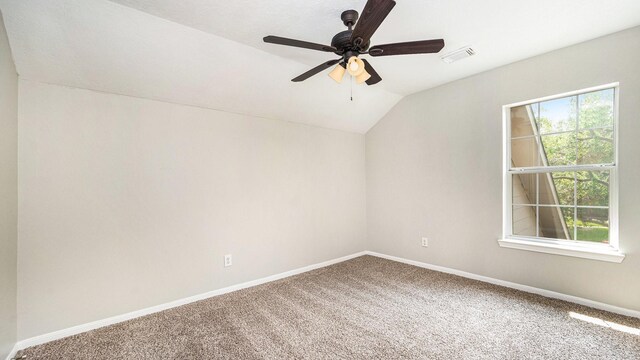 carpeted spare room featuring vaulted ceiling and ceiling fan