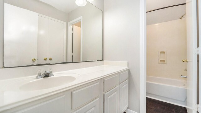 bathroom with hardwood / wood-style floors, shower / tub combination, and vanity