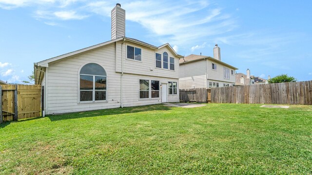 rear view of property featuring a lawn