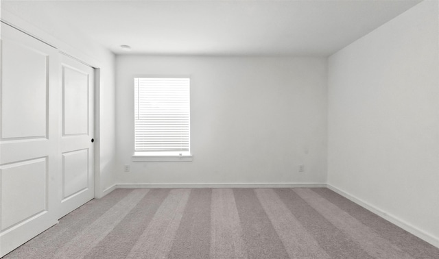 unfurnished room featuring light carpet