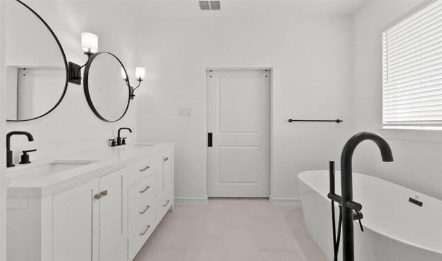 bathroom featuring vanity, a bath, and a healthy amount of sunlight